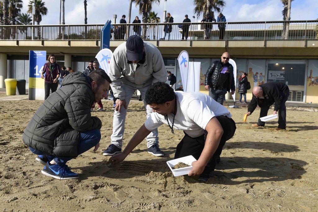 40 personas en riesgo de exclusión social participan en la limpieza de la playa del Somorrostro